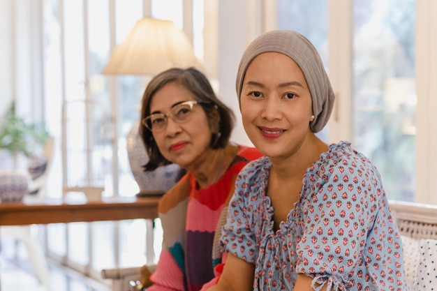 Portrait d'une mère et d'une fille senior asiatiques assises ensemble sur un canapé à la maison