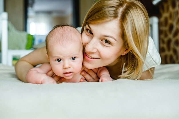 Photo portrait de mère heureuse et bébé à la maison.