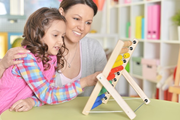 Portrait de mère avec petite fille comptant avec boulier