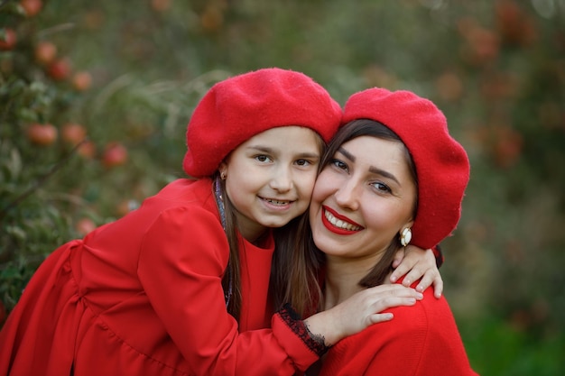 Portrait d'une mère avec sa fille dans un verger de pommiers au coucher du soleil