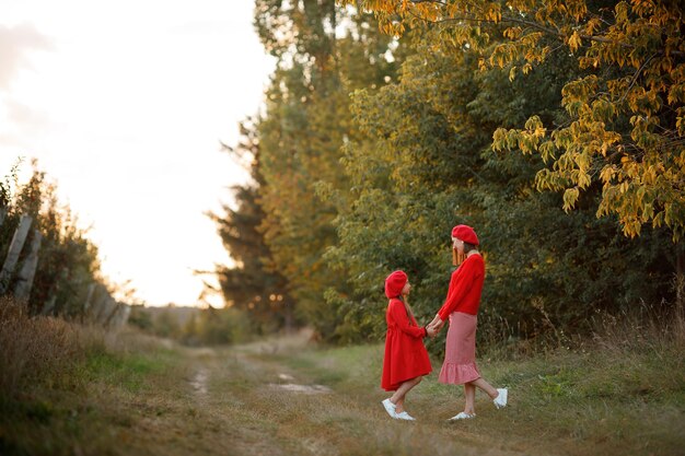 Portrait d'une mère avec sa fille dans un verger de pommiers au coucher du soleil