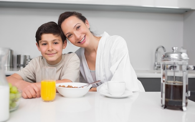 Portrait d&#39;une mère souriante avec fils dans la cuisine