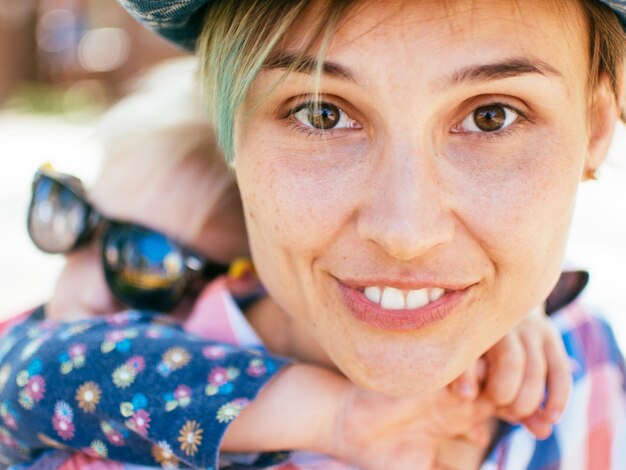 Photo portrait d'une mère souriante qui fait monter sa fille sur le dos