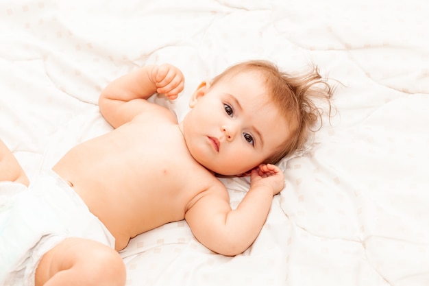 Portrait d'un mignon bébé de 6 mois allongé sur une couverture. petit bébé heureux