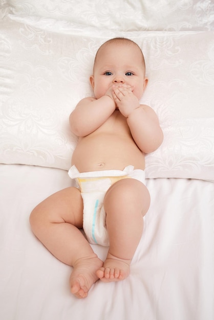 Photo portrait d'un mignon bébé allongé sur le lit à la maison