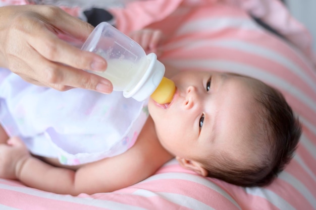 Portrait de mignon bébé nouveau-né buvant une bouteille de lait