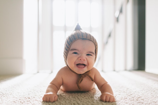 Photo portrait d'un mignon bébé sur le tapis à la maison