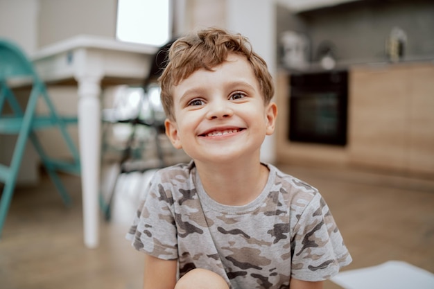 Portrait d'un mignon garçon d'âge scolaire heureux faisant des grimaces et regardant la caméra