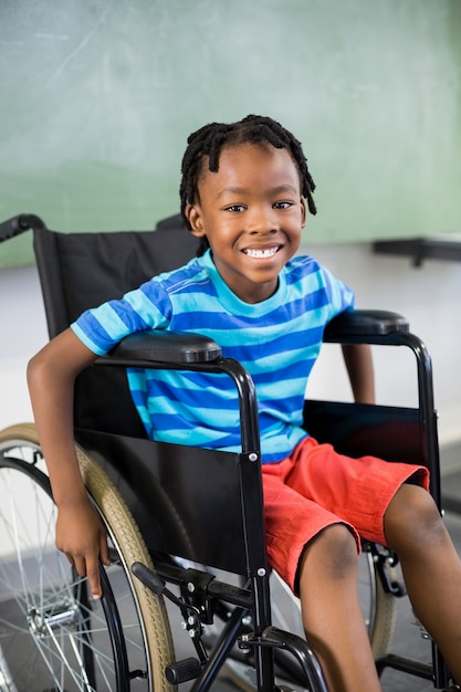 Photo portrait de mignon garçon assis sur un fauteuil roulant