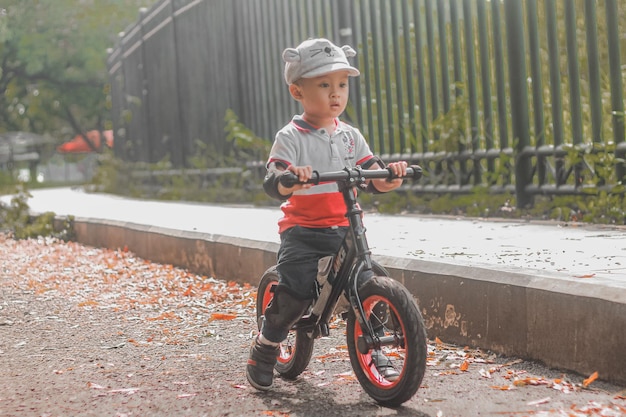 Portrait d'un mignon garçon en bas âge qui fait du vélo.