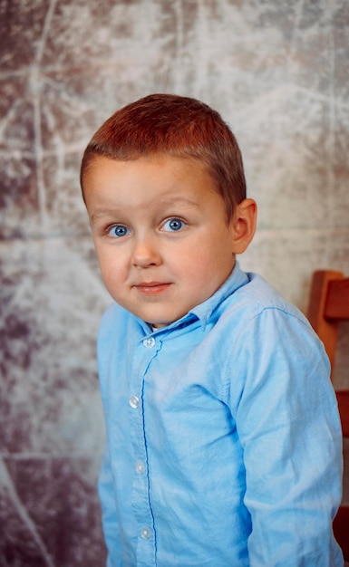 portrait d'un mignon garçon dans une chemise bleue