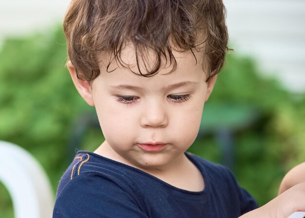 Portrait d'un mignon jeune garçon jouant dans le jardin