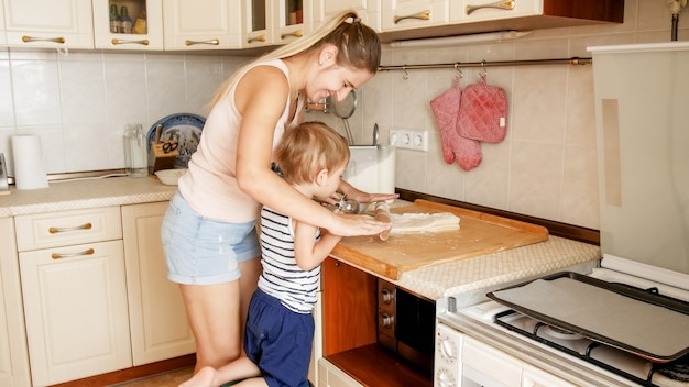 Portrait d'un mignon petit garçon de 3 ans cuisinant des biscuits avec sa mère