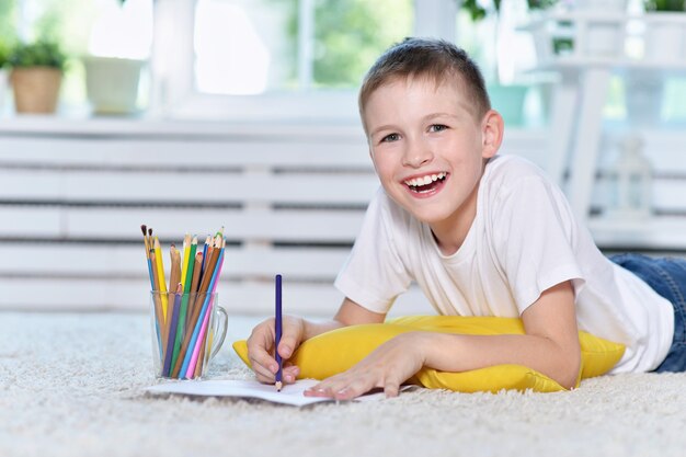 Portrait d'un mignon petit garçon dessinant à la maison