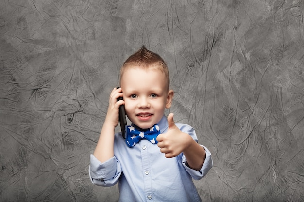 Portrait d'un mignon petit garçon avec un téléphone