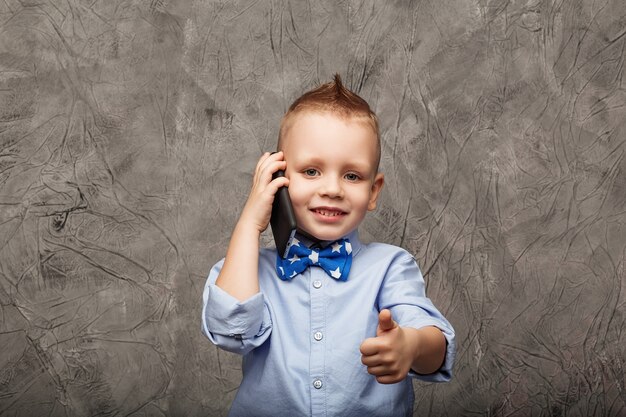 Portrait d'un mignon petit garçon avec un téléphone