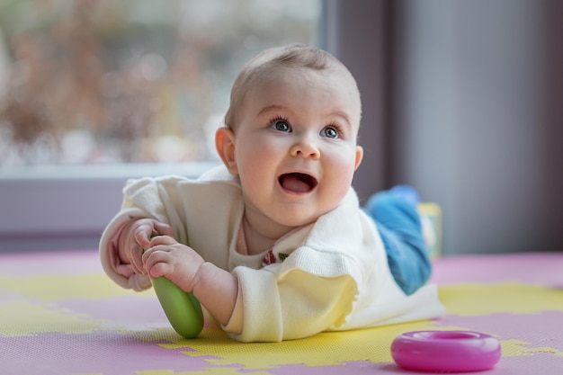 Portrait d'une mignonne petite fille allongée sur un tapis de puzzle