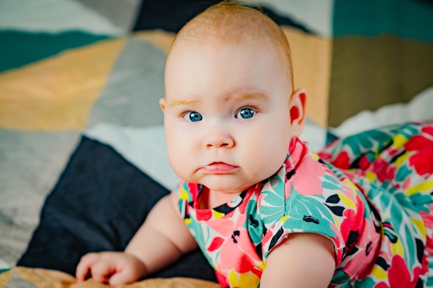 Portrait d'une mignonne petite fille aux yeux bleus dans une robe colorée