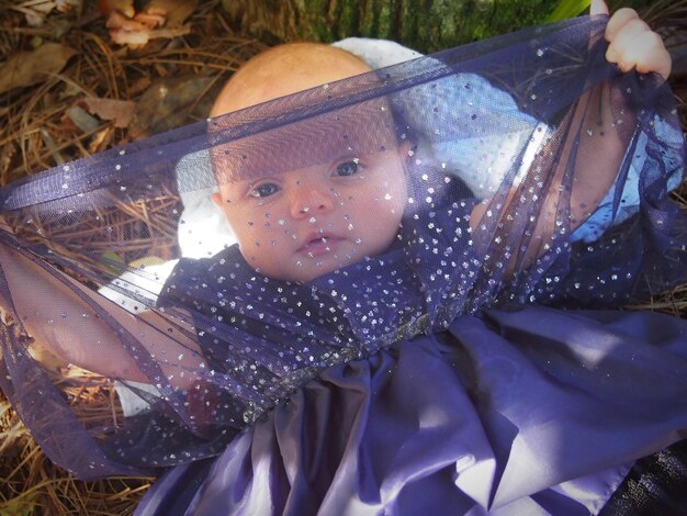 Photo portrait d'une mignonne petite fille tenant un filet de robe sur le terrain