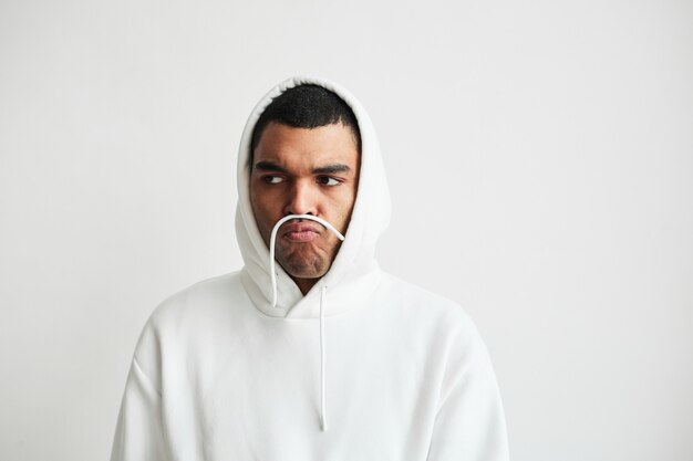 Portrait minimal d'un jeune homme portant un sweat à capuche et faisant des grimaces, espace de copie