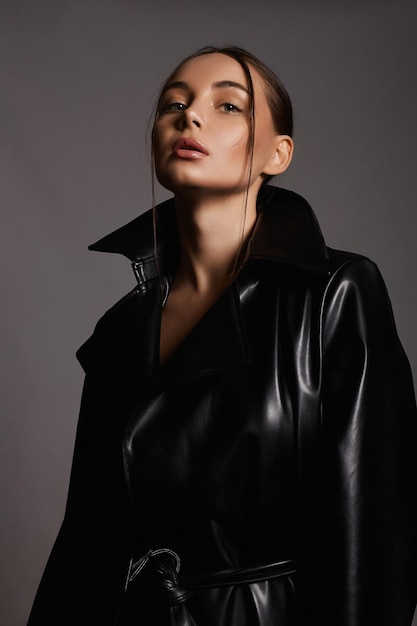 Portrait de mode d'une belle femme en trench-coat en cuir