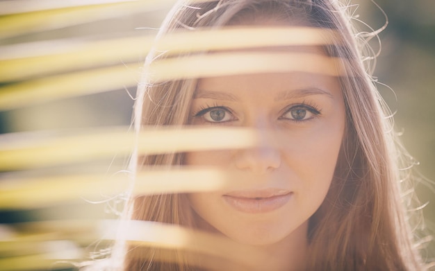 Portrait de mode d'une belle jeune fille blonde debout dans les paumes et regardant avec ses yeux parfaits sur Bali