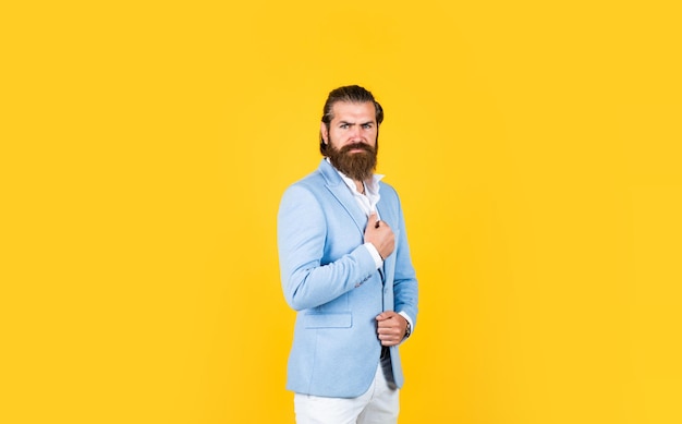 Portrait de mode d'un homme d'affaires confiant a une coiffure à la mode masculine avec une barbe ayant un look formel beauté masculine et mode bel homme avec moustache barbu hipster mature porter une veste