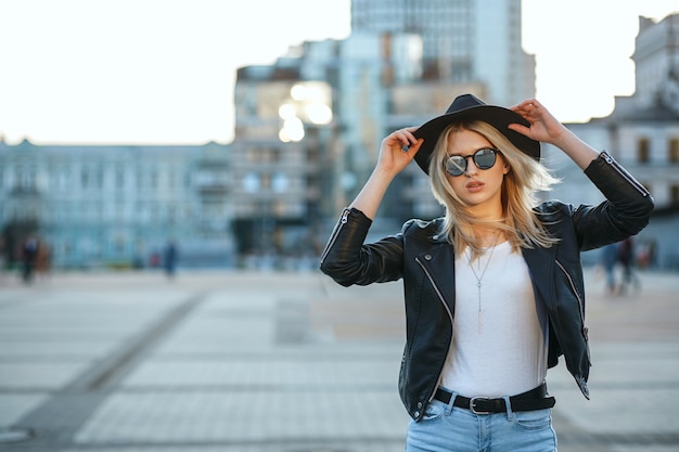Portrait de mode en plein air d'une belle femme blonde portant un chapeau et des lunettes de soleil miroir. Espace pour le texte