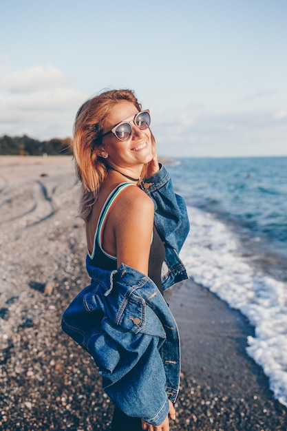 Portrait de mode en plein air d'une femme élégante sur la plage.