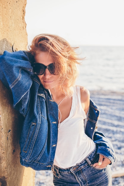 Portrait de mode en plein air d'une femme élégante sur la plage.