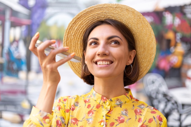 Portrait de mode en plein air de femme en robe d'été jaune sur le mur coloré de la rue