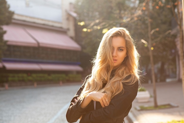 Portrait de mode de vie d'une fille blonde séduisante marchant dans la ville d'automne au coucher du soleil. Espace pour le texte