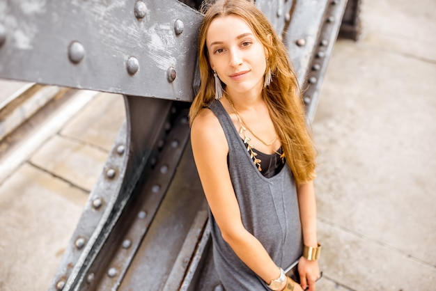 Portrait de mode de vie d'une jeune femme souriante élégante à l'extérieur sur le vieux pont de fer