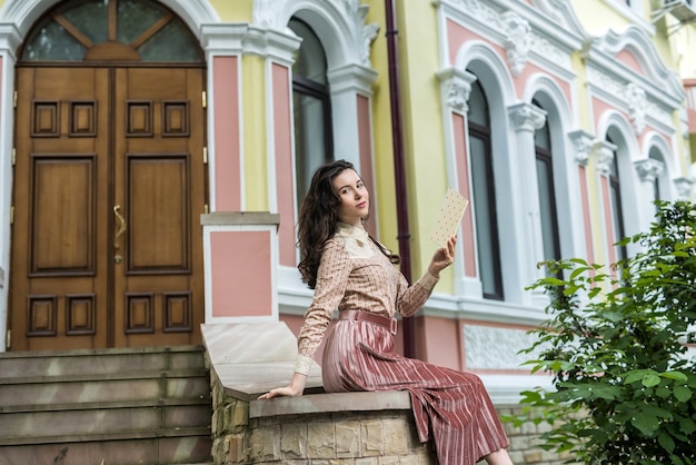 Portrait de mode de vie d'une jolie dame près de la maison dans la rue de la ville