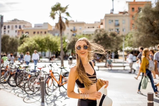 Portrait de mode de vie d'une jolie femme avec chapeau marchant sur la promenade de la plage à Barcelone