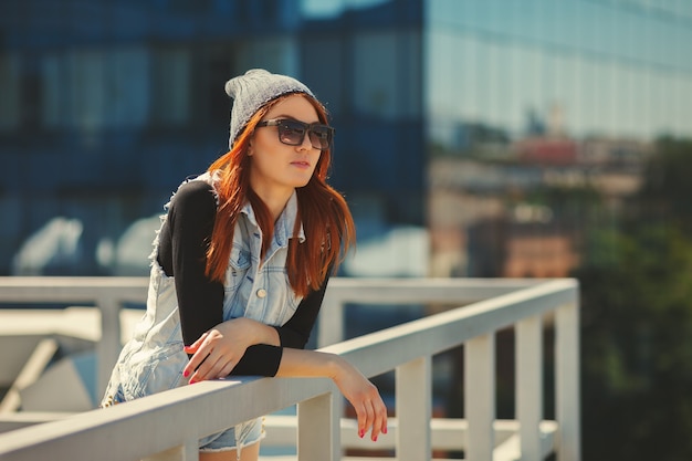 Portrait de mode de vie de mode en plein air de jolie jeune fille, portant en arrière-plan urbain de style grunge swag hipster. Concept de ville garçon manqué