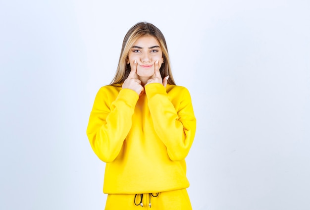 Portrait d'un modèle de belle femme debout et pointant sur ses joues