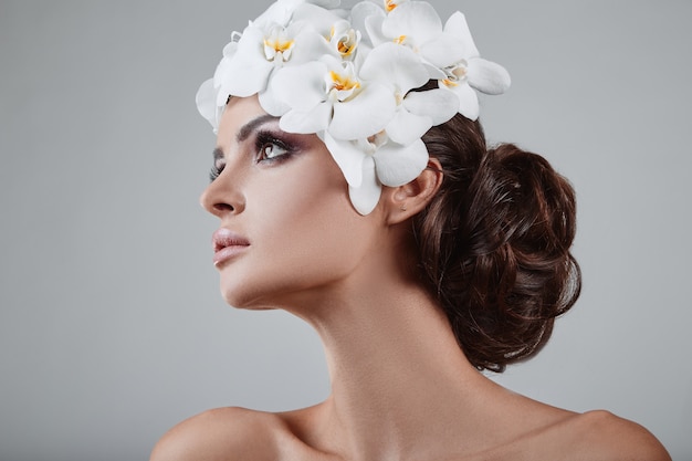 Portrait de modèle brune belle, glamour, sensuelle avec des fleurs