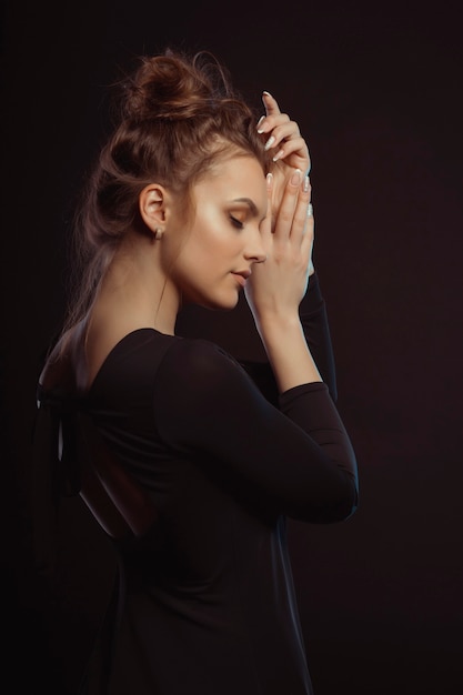 Portrait de modèle brune tendre dans l'ombre au studio