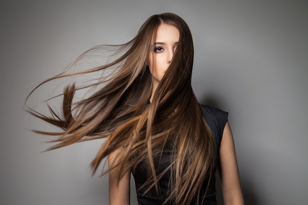 Portrait d'un modèle calme et sans émotion avec de longs cheveux venteux. Prise de vue en studio.