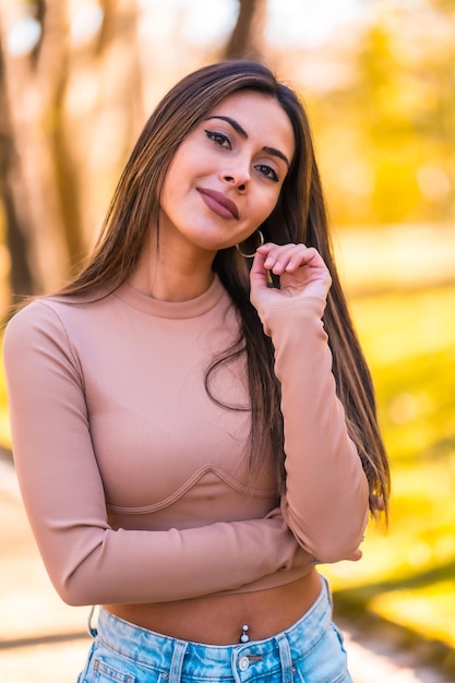 Portrait d'un modèle caucasien avec un pull rose et un jean marchant dans un parc en automne