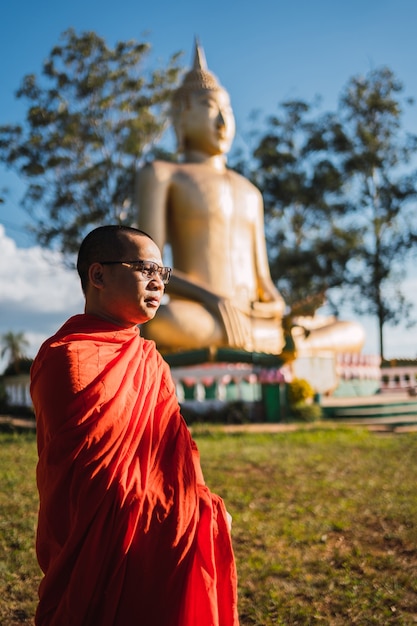 Portrait d'un moine bouddhiste, en arrière-plan l'image du plus grand Bouddha d'Amérique du Sud