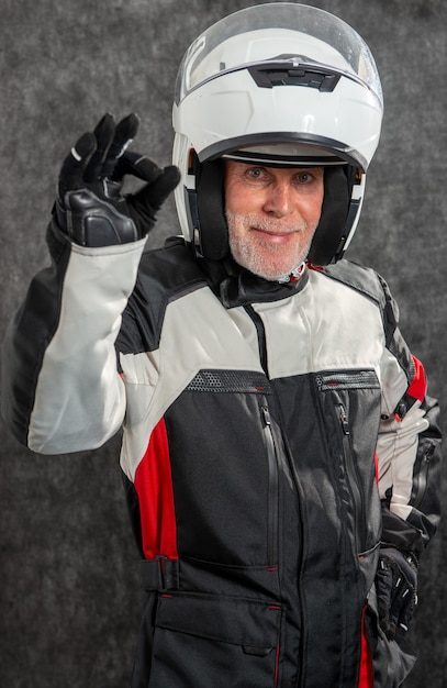 Portrait de motard senior avec un casque blanc OK
