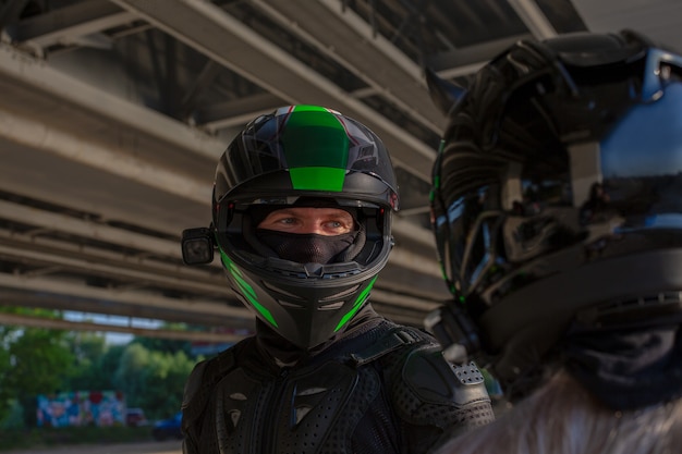 Portrait de motards homme et femme en casques se regardent. Concept d'amour de moto. Cavaliers de l'extrême