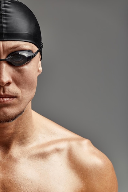 Portrait d'un nageur en masque recadré portrait jeune athlète nageur portant une casquette et un masque pour nager des copies de fond gris de l'espace