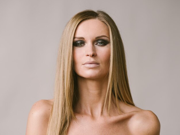 Portrait naturel blond cheveux longs belle femme avec maquillage beauté. Prise de vue en studio.