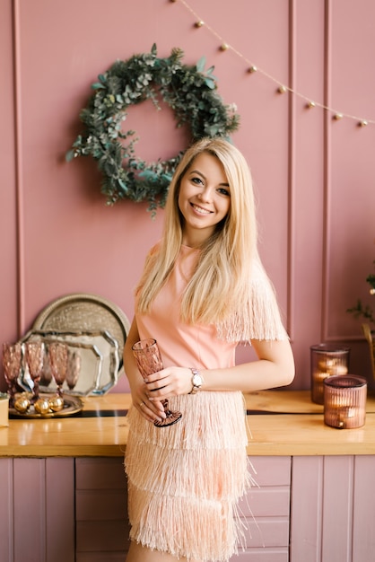 Portrait de Noël d'une jeune fille dans une robe rose et un manteau en peau de mouton