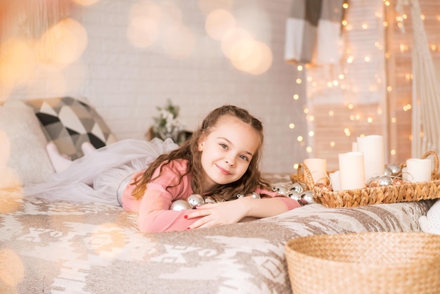Portrait de Noël d'une jeune fille avec des décorations de Noël. Guirlandes lumineuses et lumières créent une atmosphère magique.