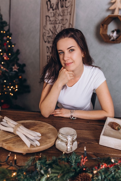 Portrait de Noël de jeune jolie femme brune à la maison confortable