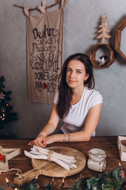 Portrait de Noël de jeune jolie femme brune à la maison confortable